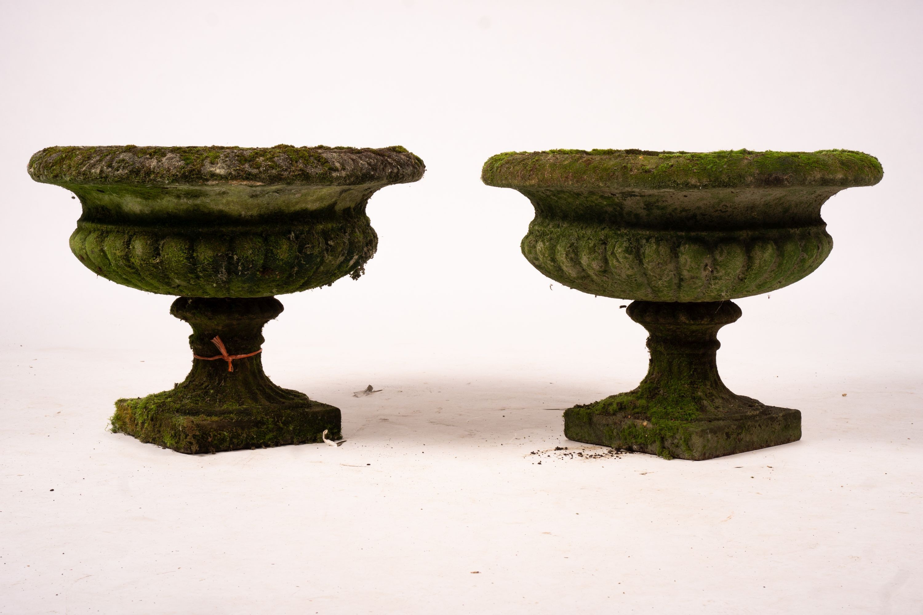 A pair of weathered reconstituted stone campana garden urns, Diam.56cm H.42cm